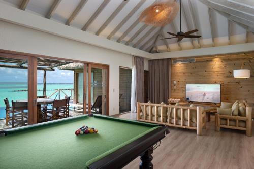 a living room with a pool table and a television at You & Me Maldives - Adults Only - Premium All-Inclusive in Raa Atoll