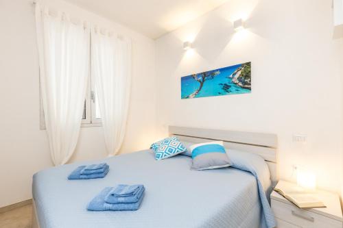 a bedroom with a bed with blue towels on it at Navarra Beach House in Santa Maria Navarrese