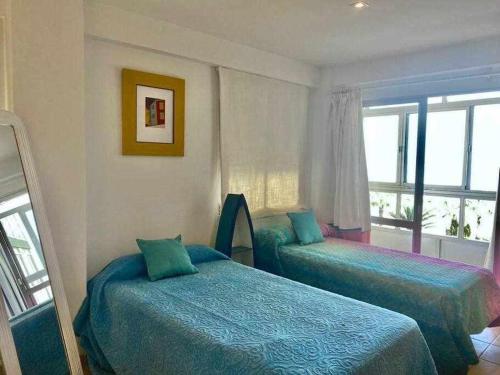 a bedroom with two beds and a window at Apartamento Sea View By Solymar Holiday in Torre del Mar