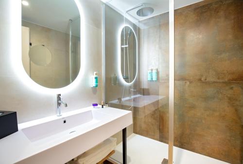a bathroom with a sink and a mirror at Mercure Aix en Provence Beaumanoir in Aix-en-Provence