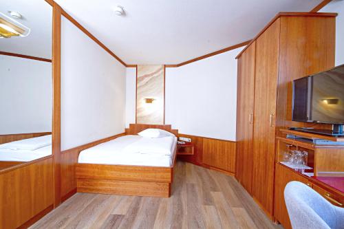 a small room with two beds and a tv at Vienna Sporthotel in Vienna