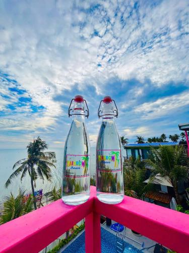 two empty plastic bottles sitting on a pink rail at Rainbow Beach Mũi Né - Homestay & Coffee in Ấp Khánh Phước (1)