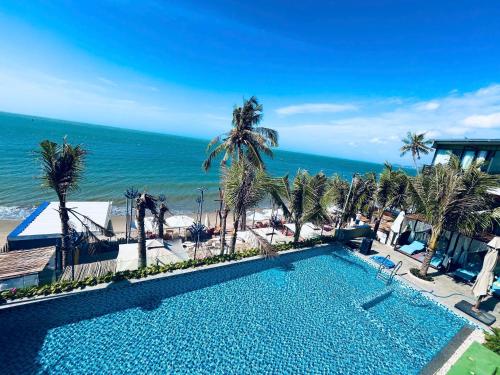 a swimming pool with a view of the ocean at Rainbow Beach Mũi Né - Homestay & Coffee in Ấp Khánh Phước (1)