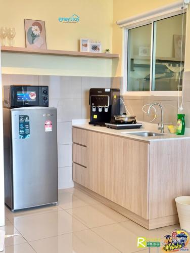 a kitchen with a refrigerator and a sink at Amber Cove Impression City By Heystay Management in Melaka