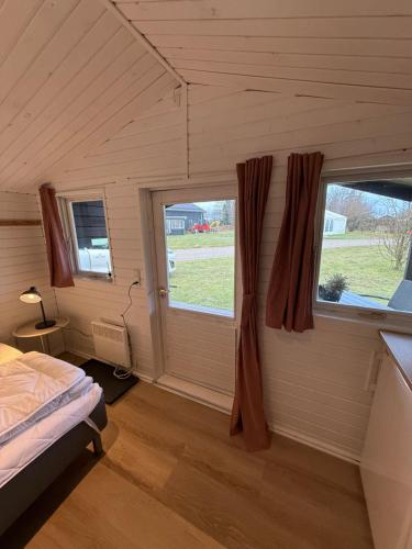 a bedroom with a bed and a large window at Himmerland camping & Feriecenter in Års