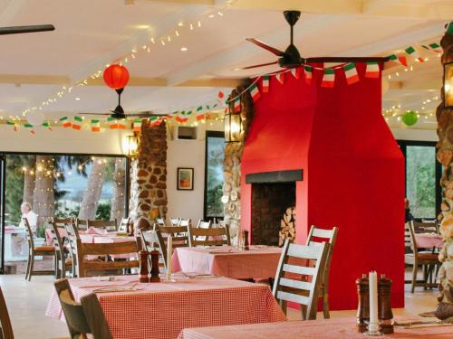 a dining room with tables and a red wall at Duikersdrift Winelands Country Escape in Tulbagh