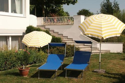 een groep stoelen en parasols in een tuin bij Gästehaus Schiff in Meersburg