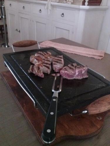 a tray of meat on a table with a knife at Hotel Cavalieri in Passignano sul Trasimeno