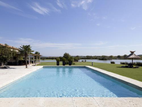 une piscine avec vue sur un plan d'eau dans l'établissement Mas de la Galégière - Les Chambres d'Hôtes, à Arles