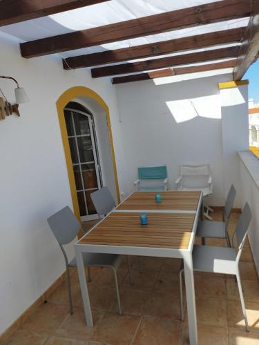 a dining room with a wooden table and chairs at Cozy Apartment Cabanas de Tavira in Cabanas de Tavira