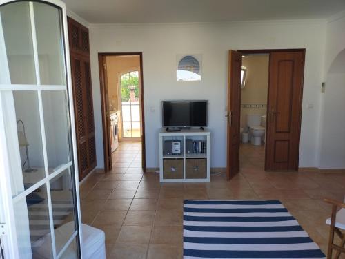 a living room with a flat screen tv and a tv stand at Cozy Apartment Cabanas de Tavira in Cabanas de Tavira