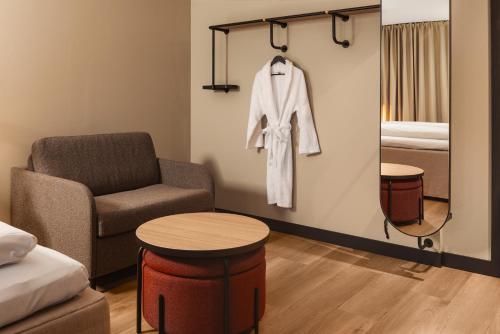 a room with a chair and a bed and a table at Scandic Holberg in Oslo