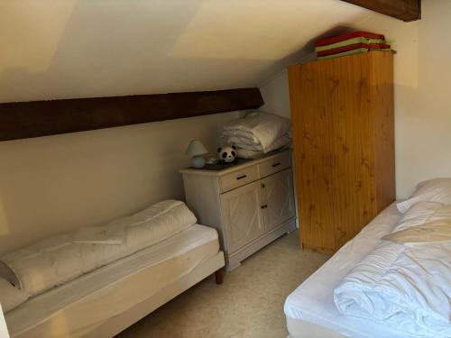 une chambre avec deux lits et une armoire en bois dans l'établissement Bonheur, à Saint Cyprien Plage