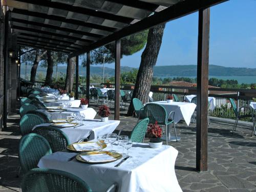 une rangée de tables avec des assiettes et des verres sur elles dans l'établissement Hotel Cavalieri, à Passignano sul Trasimeno