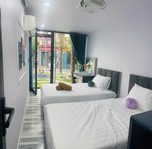 two beds in a room with a window at Rainbow Beach Mũi Né - Homestay & Coffee in Ấp Khánh Phước (1)