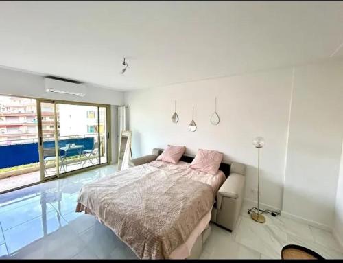 une chambre avec un lit et une grande fenêtre dans l'établissement Studio moderne à Juan les Pins - 30 m² avec balcon, à Juan-les-Pins