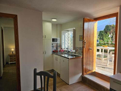 a kitchen with a sink and a counter with a window at Embrujo Andaluz Complejo Rural Órgiva in Órgiva