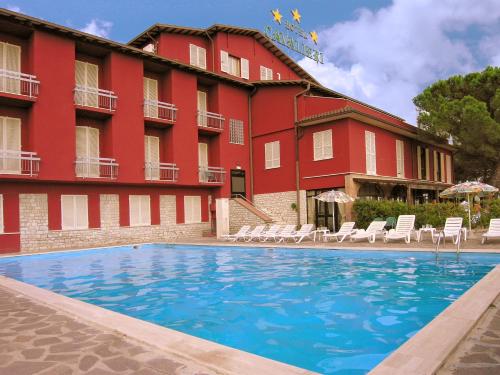 un hotel con piscina frente a un edificio en Hotel Cavalieri en Passignano sul Trasimeno