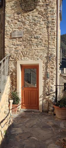 a wooden door on a stone building with a stone wall at Casa Pablo in Badalucco