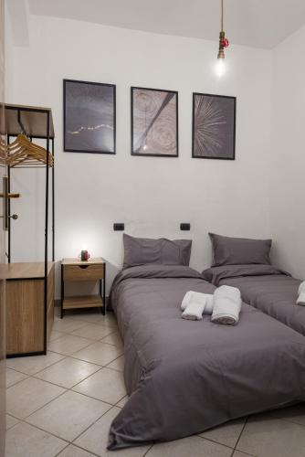 a bedroom with two beds and a cross on the wall at In Centro a Certaldo in Certaldo