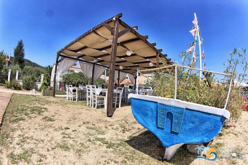 a blue and white boat sitting under a tent at Vournelis Beach Hotel and Spa in Iraklitsa
