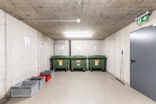 an empty room with four green bins and a door at Berg Aparts Faschina - 02 in Fontanella