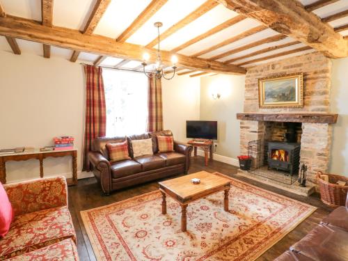 a living room with a couch and a fireplace at Lea Farm House in Kidderminster