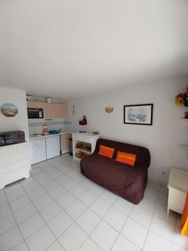 un salon avec un canapé et une cuisine dans l'établissement T3 avec large terrasse et garage, à Sète