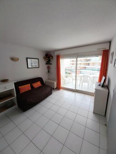 un salon avec un canapé et une grande fenêtre dans l'établissement T3 avec large terrasse et garage, à Sète