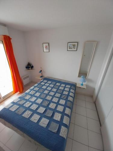 - une chambre avec un lit bleu dans l'établissement T3 avec large terrasse et garage, à Sète