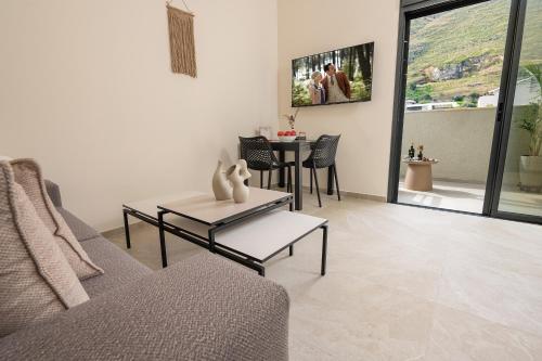 a living room with a couch and a table at נעם בגלבוע -2 סוויטות מהממות עם נוף לגלבוע in H̱efẕi Bah