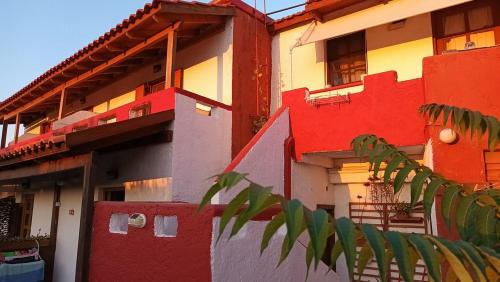 a multicolored building with a tree in front of it at Antikristo Rooms in Karteros