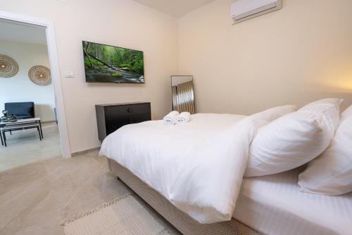 a bedroom with a white bed with two white pillows at נעם בגלבוע -2 סוויטות מהממות עם נוף לגלבוע in H̱efẕi Bah
