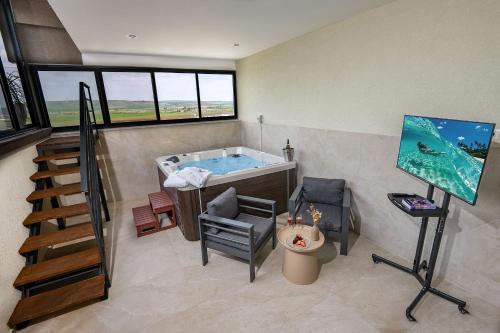 a bathroom with a tub in a room with windows at נעם בגלבוע -2 סוויטות מהממות עם נוף לגלבוע in H̱efẕi Bah
