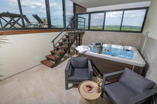 a bathroom with a tub and a chair and a staircase at נעם בגלבוע -2 סוויטות מהממות עם נוף לגלבוע in H̱efẕi Bah