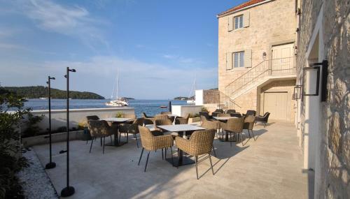 a patio with tables and chairs and the water at Marshal Hotel Heritage in Vis