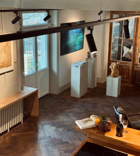 ein Wohnzimmer mit einem Tisch und einigen Fenstern in der Unterkunft Art Residence, Beat Schild in Brienz