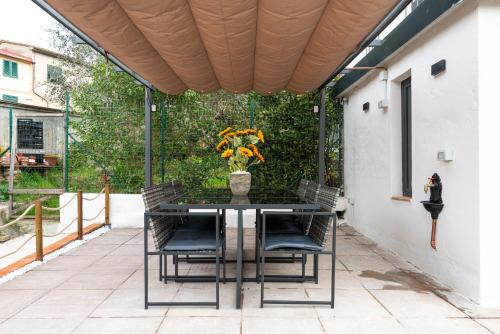 a table with chairs and a vase of flowers on a patio at In Centro a Certaldo in Certaldo