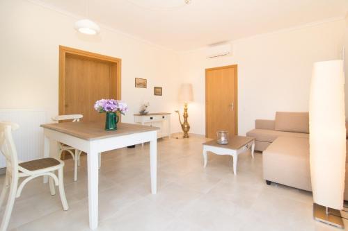 a living room with a table and a couch at Angelbay Bungalows in Agia Triada