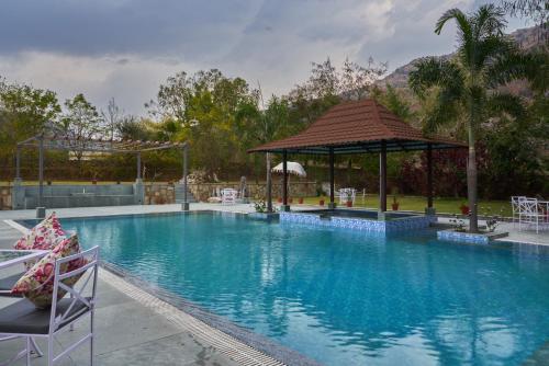 a large swimming pool with a gazebo at The Hunting Lodge - Luxury Resort in Udaipur in Udaipur