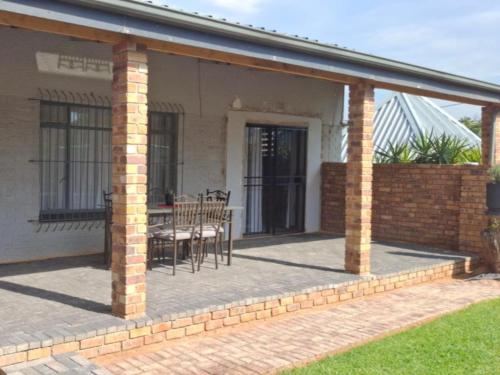 a patio with a table and chairs on a house at Villa Marais Guest House in Brakpan