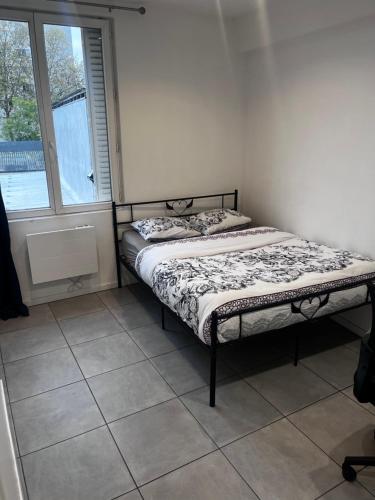 a small bed in a room with a window at Cozy bedroom in a shared apart in Saint-Denis