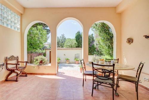 a dining room with a table and chairs and two windows at Casa Vieja in Port de Pollensa
