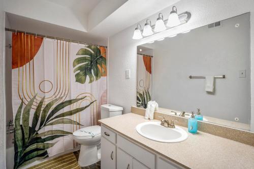 a bathroom with a sink and a toilet and a mirror at Towne Plaza Apartments 295 - 7 km from FIFA Fest in Houston