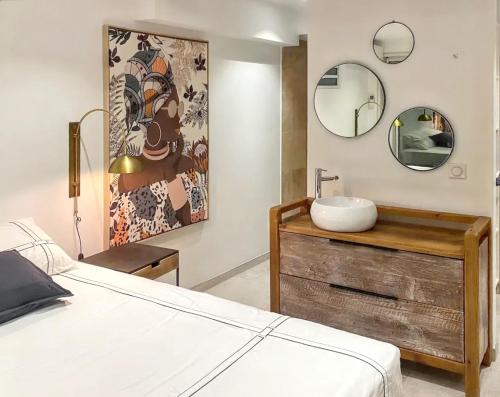 a bedroom with a sink on a wooden dresser with a mirror at Villa spacieuse Le François + piscine in Le François