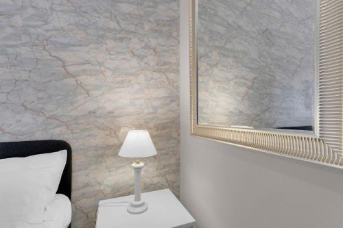 a bedroom with a mirror and a lamp on a table at The house of via muratori 11 in Milan