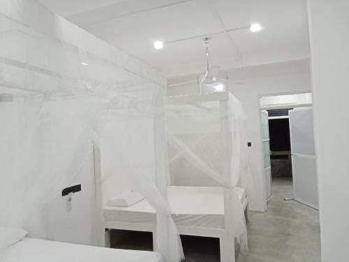 a bedroom with two bunk beds with white walls at C-Born in Hikkaduwa