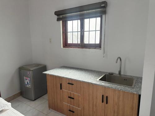 a kitchen with a sink and a window and a refrigerator at SUNNY Homestay Mui Ne in Phan Thiet