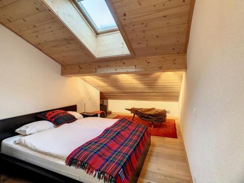 a bedroom with a bed and a skylight at Asters 8 in Verbier