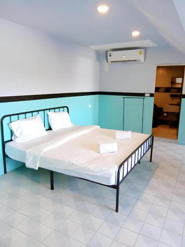 a bed with two pillows on it in a room at XX Mitr Inn Phuket Old Town -มิตร อินน์ ภูเก็ตโอลทาวน์ in Phuket